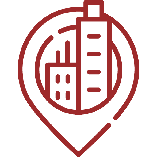 A red outline icon of a map pin containing two buildings, one tall and one shorter, representing a city location or urban area.